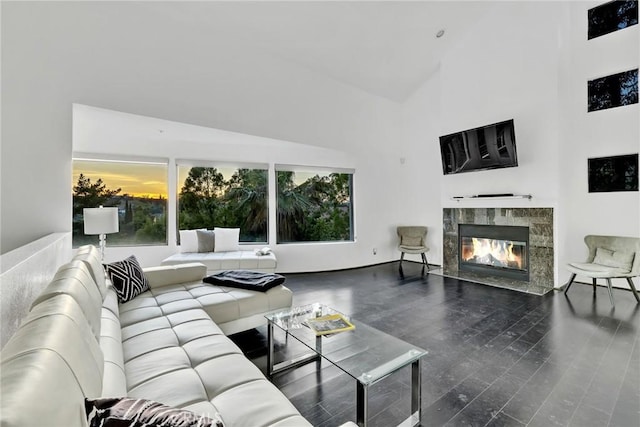 living room featuring a high end fireplace, wood-type flooring, and high vaulted ceiling