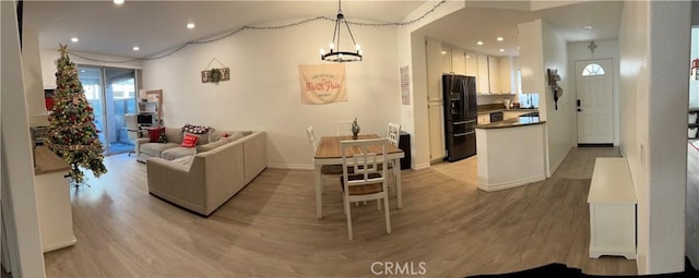 living room featuring a notable chandelier and light hardwood / wood-style flooring