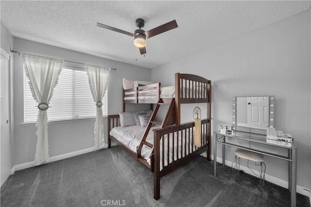 bedroom with ceiling fan, a textured ceiling, and dark colored carpet