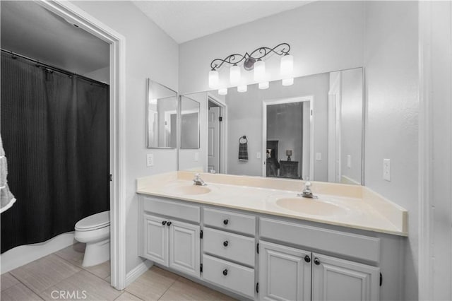 bathroom featuring tile patterned flooring, vanity, and toilet