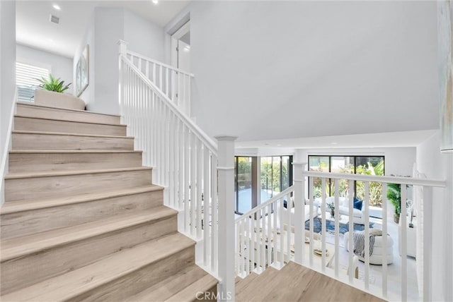 stairway with hardwood / wood-style flooring and french doors