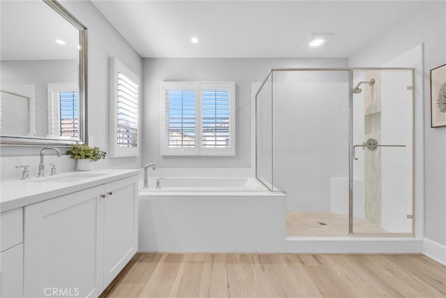 bathroom with separate shower and tub, vanity, and hardwood / wood-style floors