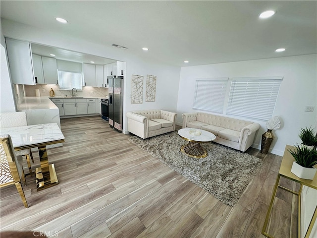 living room with sink and light wood-type flooring