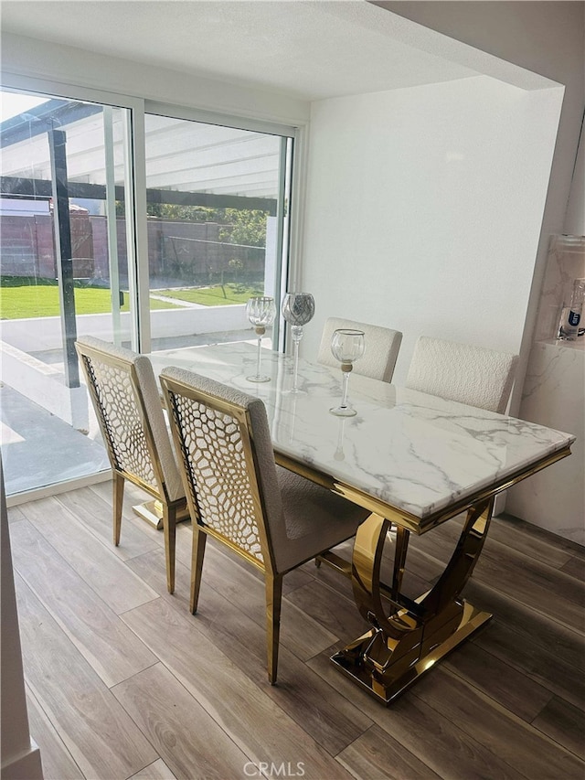 dining area with a healthy amount of sunlight and hardwood / wood-style flooring