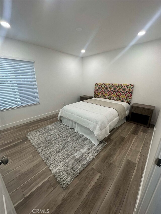 bedroom with dark wood-type flooring