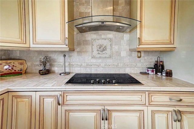 kitchen with ventilation hood, black electric stovetop, decorative backsplash, and cream cabinets