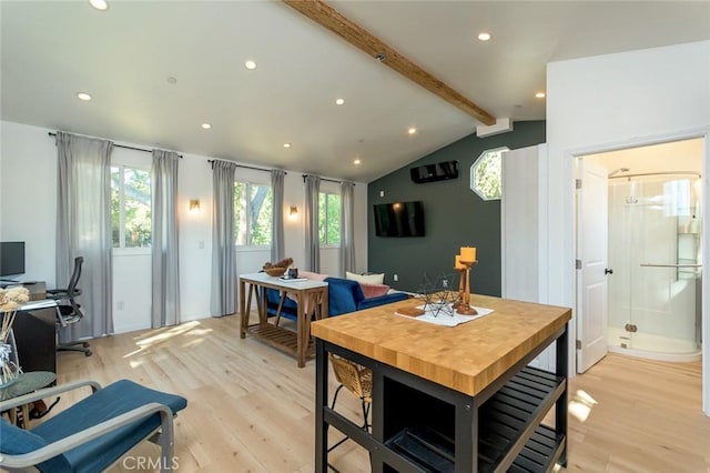 dining area with vaulted ceiling with beams and light hardwood / wood-style floors