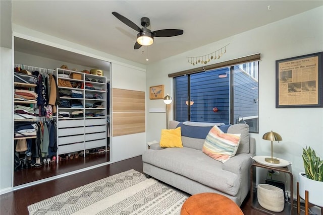 living room featuring ceiling fan and dark wood-type flooring