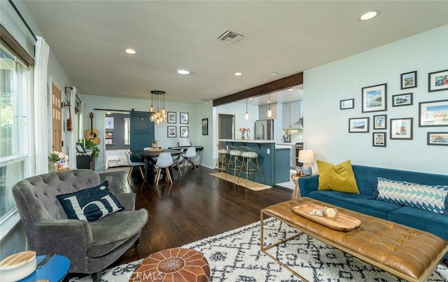 living room with a barn door and hardwood / wood-style flooring