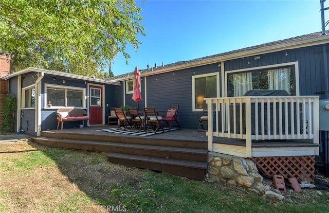 rear view of house featuring a wooden deck