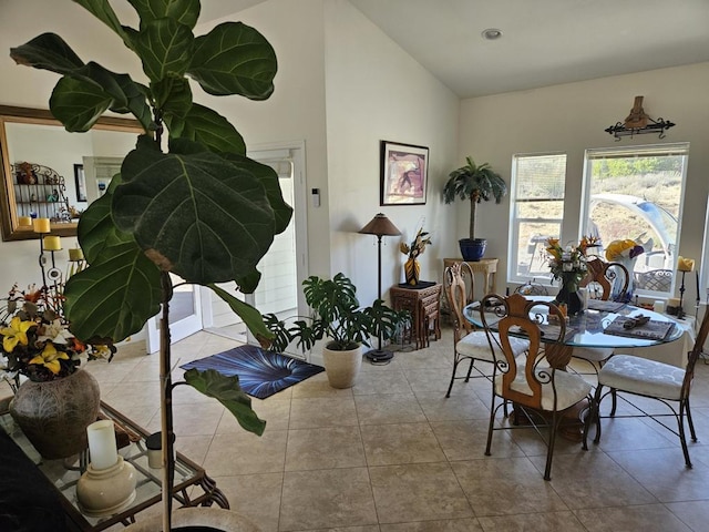 tiled dining room featuring vaulted ceiling