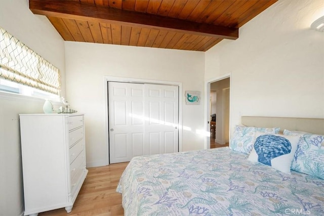 bedroom with lofted ceiling with beams, a closet, light hardwood / wood-style flooring, and wooden ceiling