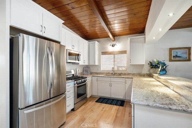 kitchen with light stone countertops, white cabinetry, sink, stainless steel appliances, and light hardwood / wood-style flooring