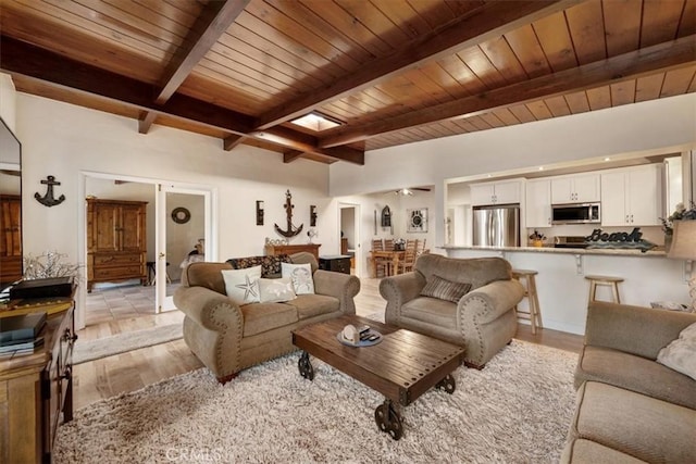 living room featuring beam ceiling, ceiling fan, wooden ceiling, and light hardwood / wood-style floors