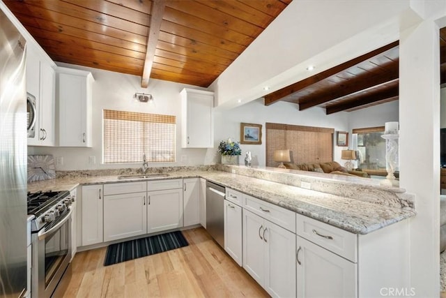 kitchen with white cabinets, sink, vaulted ceiling with beams, appliances with stainless steel finishes, and light hardwood / wood-style floors