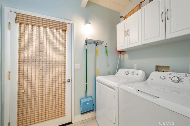 washroom featuring cabinets, washing machine and dryer, and light tile patterned flooring