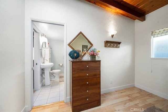 corridor with beam ceiling, wooden ceiling, sink, and light hardwood / wood-style flooring