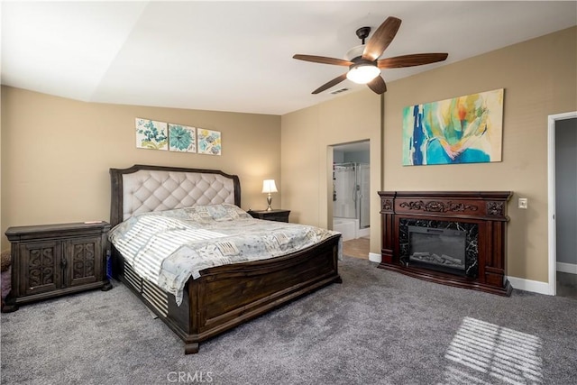 carpeted bedroom featuring ceiling fan, vaulted ceiling, a high end fireplace, and ensuite bath