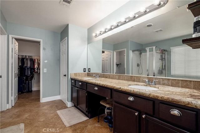 bathroom with tile patterned flooring, vanity, and a shower with shower door