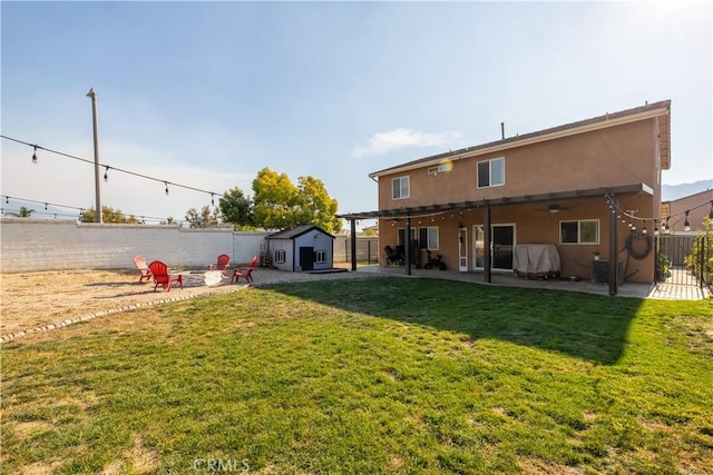 rear view of house with a patio area, a storage shed, a yard, and central AC