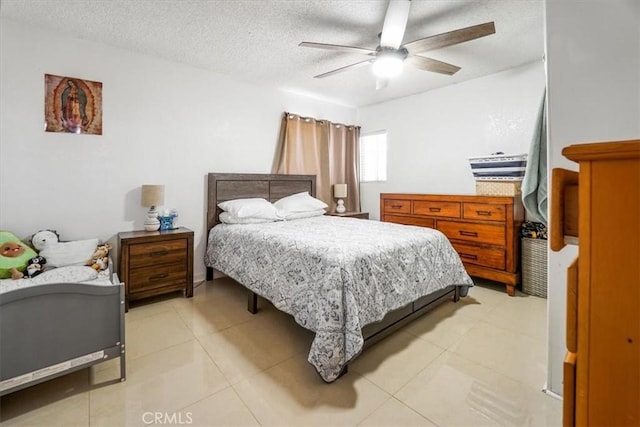 bedroom featuring ceiling fan, light tile patterned floors, and a textured ceiling