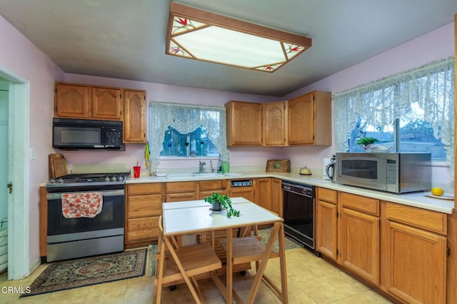 kitchen with a healthy amount of sunlight, sink, light tile patterned floors, and black appliances