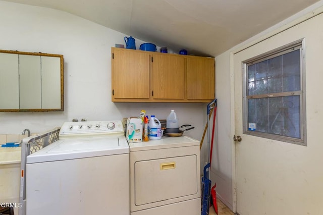 clothes washing area featuring cabinets and washing machine and clothes dryer