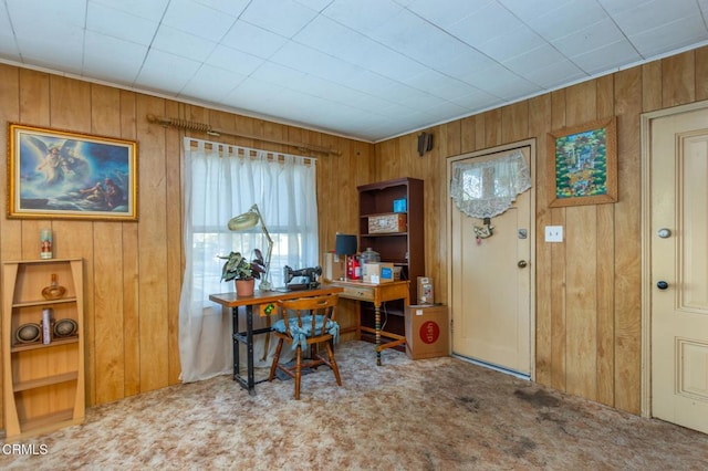 home office featuring carpet and wood walls