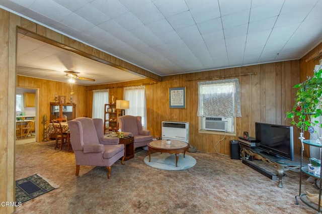 carpeted living room featuring cooling unit, heating unit, wooden walls, and ceiling fan