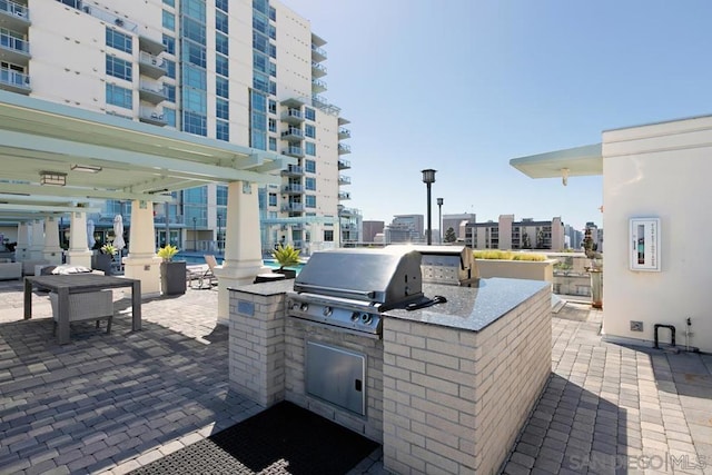 view of patio featuring an outdoor kitchen and a grill