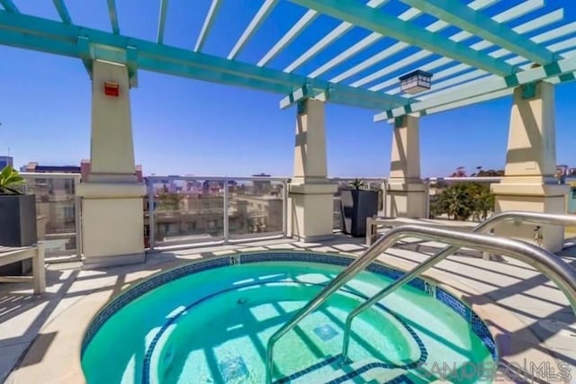 view of swimming pool featuring a pergola and a hot tub