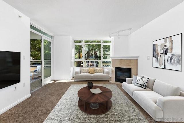 carpeted living room featuring plenty of natural light, rail lighting, and a tile fireplace