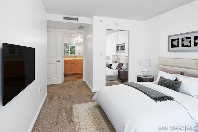 bedroom featuring light carpet, ensuite bathroom, and sink