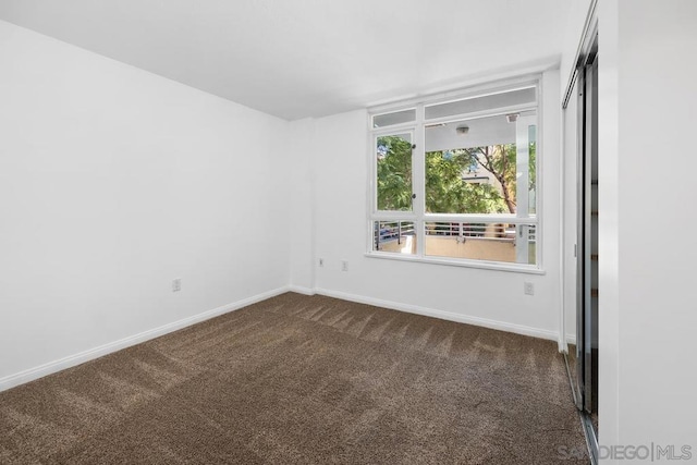 empty room featuring dark carpet