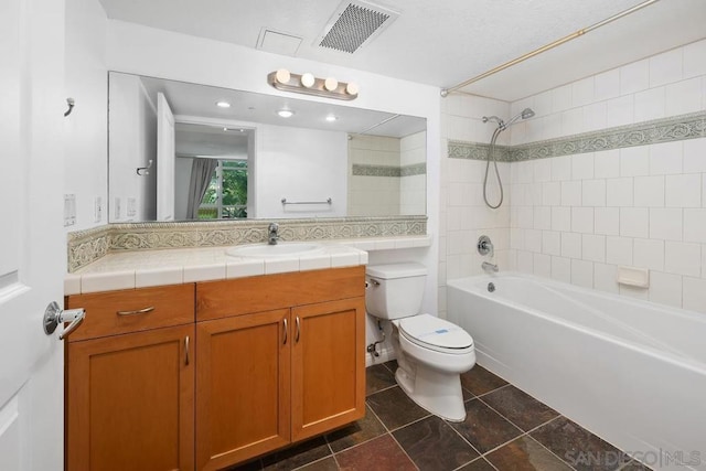 full bathroom with vanity, tiled shower / bath combo, and toilet