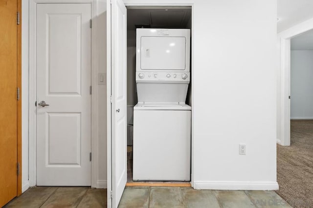 laundry room with light colored carpet and stacked washer and clothes dryer