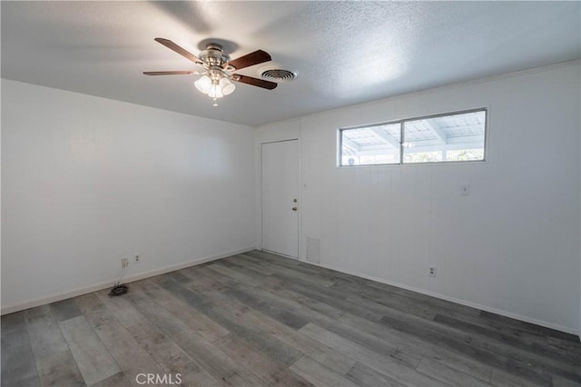 unfurnished room with a textured ceiling, dark hardwood / wood-style flooring, and ceiling fan