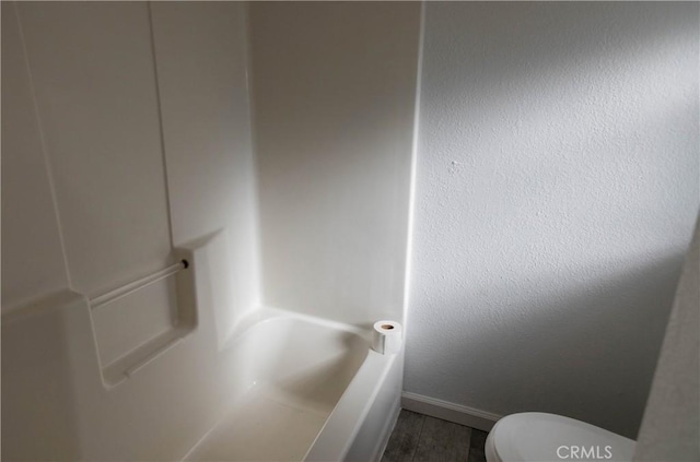 bathroom featuring a washtub and toilet