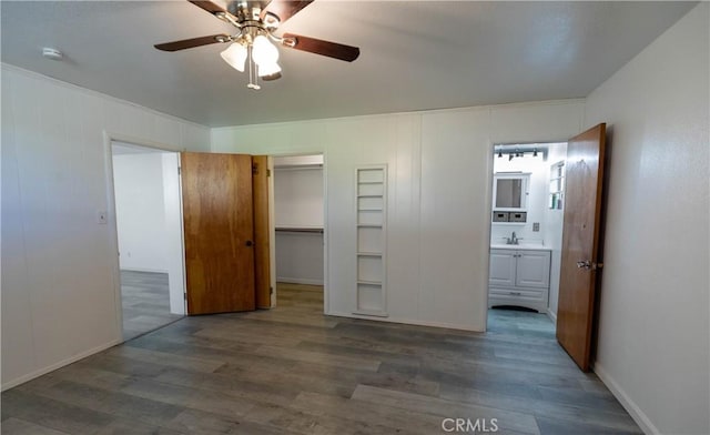 unfurnished bedroom with ceiling fan, sink, dark hardwood / wood-style flooring, ensuite bathroom, and a closet