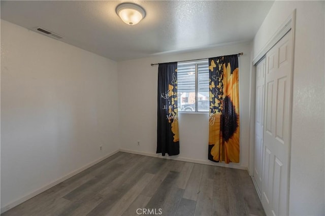 empty room with hardwood / wood-style flooring