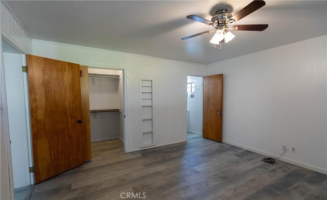 unfurnished bedroom with ceiling fan, dark wood-type flooring, and a closet