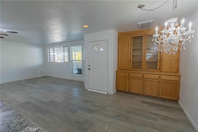 foyer entrance with ceiling fan with notable chandelier and light hardwood / wood-style flooring