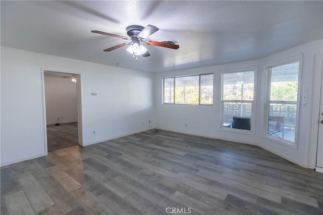 spare room featuring ceiling fan and dark hardwood / wood-style flooring