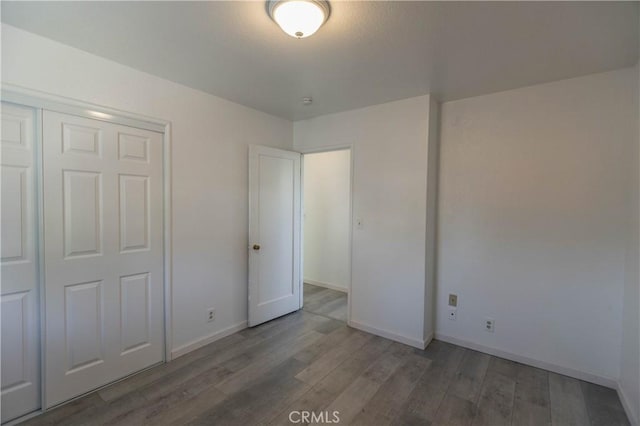 unfurnished bedroom with wood-type flooring and a closet