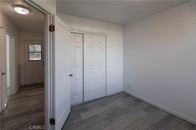 unfurnished bedroom featuring dark hardwood / wood-style floors and a closet