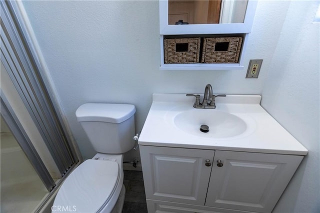 bathroom featuring vanity, toilet, and an enclosed shower