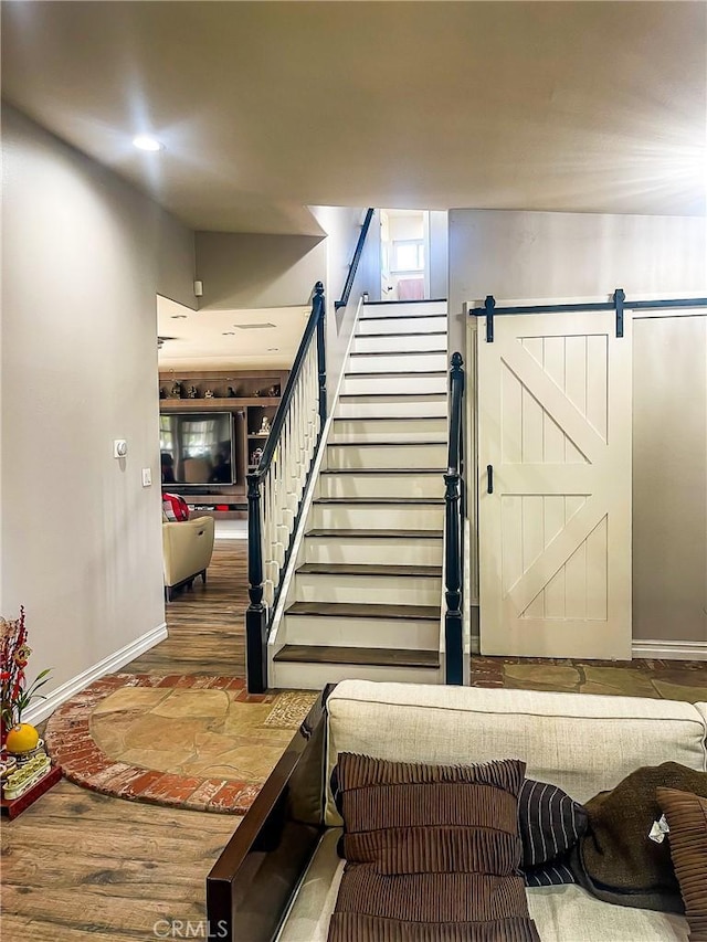 stairs with wood-type flooring and a barn door