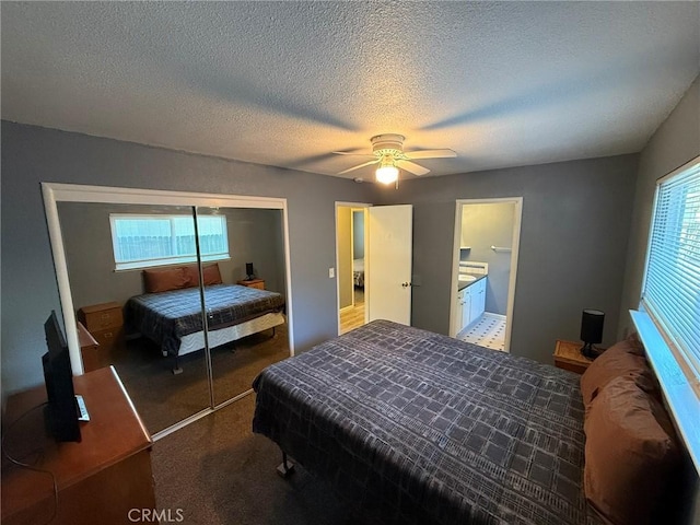 carpeted bedroom with ceiling fan, a closet, and a textured ceiling