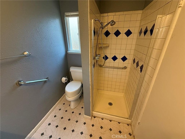 bathroom featuring tiled shower and toilet