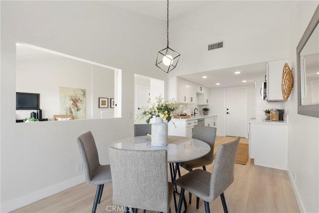 dining area with light wood-type flooring and sink